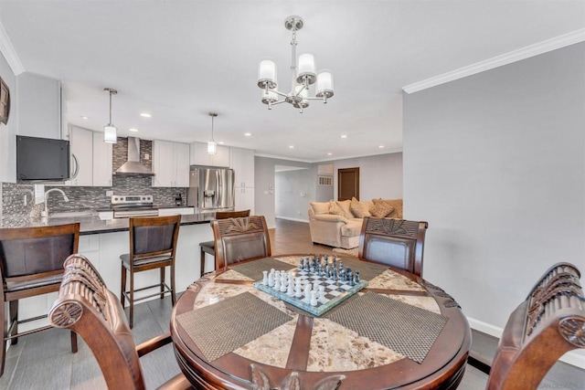 dining space featuring crown molding, sink, and a notable chandelier