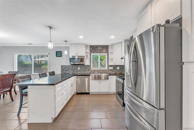 kitchen with a breakfast bar area, stainless steel appliances, white cabinets, decorative light fixtures, and kitchen peninsula