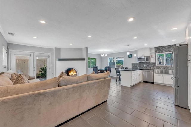 living room with an inviting chandelier, sink, and french doors