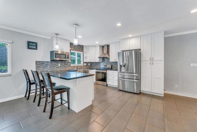 kitchen featuring decorative light fixtures, white cabinets, kitchen peninsula, stainless steel appliances, and wall chimney exhaust hood