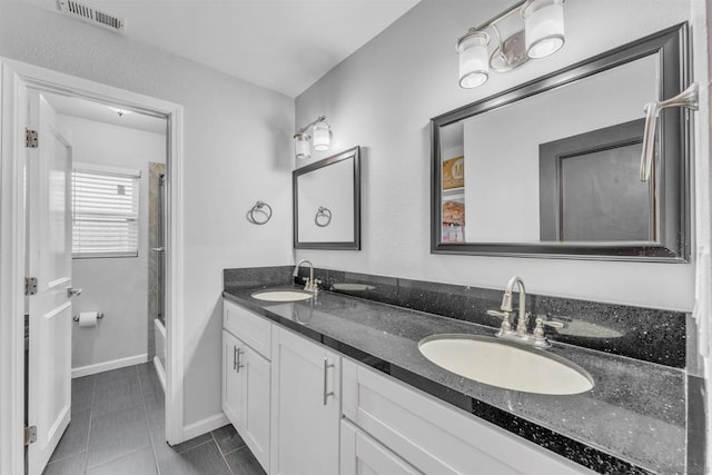 bathroom featuring vanity, tile patterned floors, and combined bath / shower with glass door