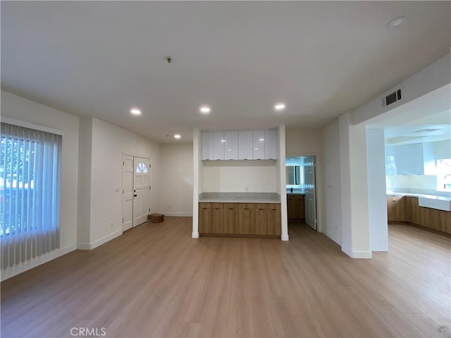 unfurnished living room featuring light wood-type flooring, plenty of natural light, and recessed lighting