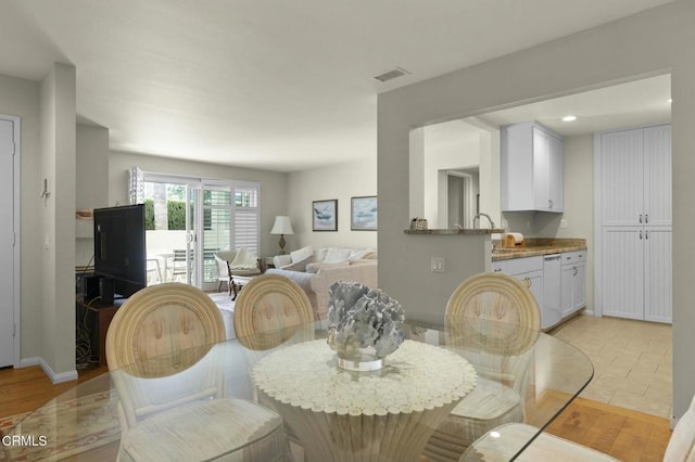 dining room with sink and light hardwood / wood-style floors