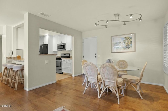 dining space with light hardwood / wood-style floors