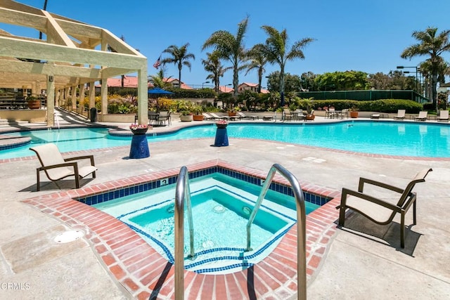 view of pool with a hot tub, a pergola, and a patio