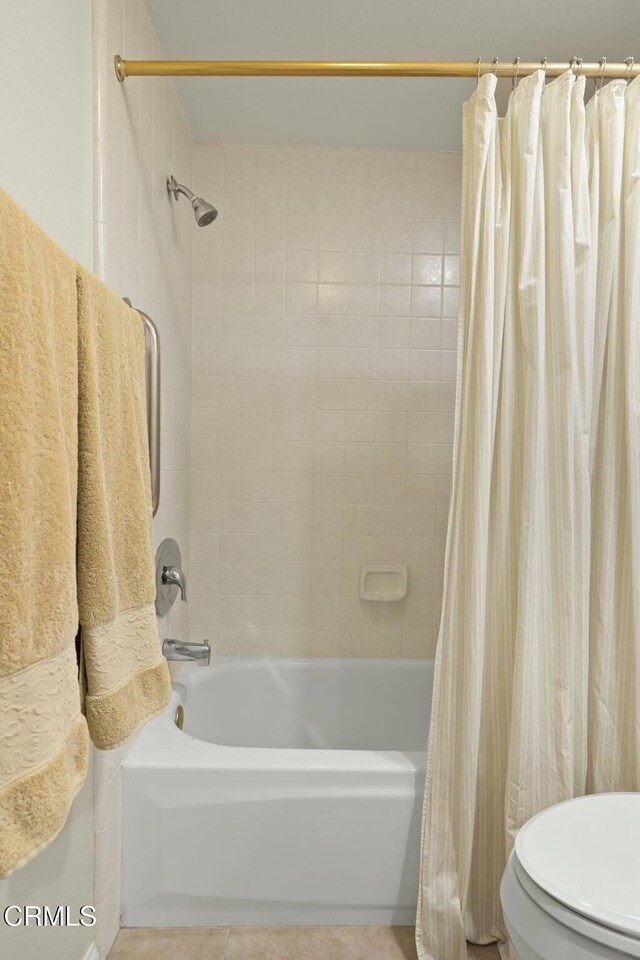 bathroom featuring tile patterned flooring, shower / tub combo, and toilet