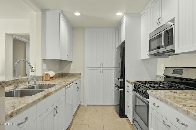 kitchen with white cabinetry, sink, stainless steel appliances, and light stone countertops