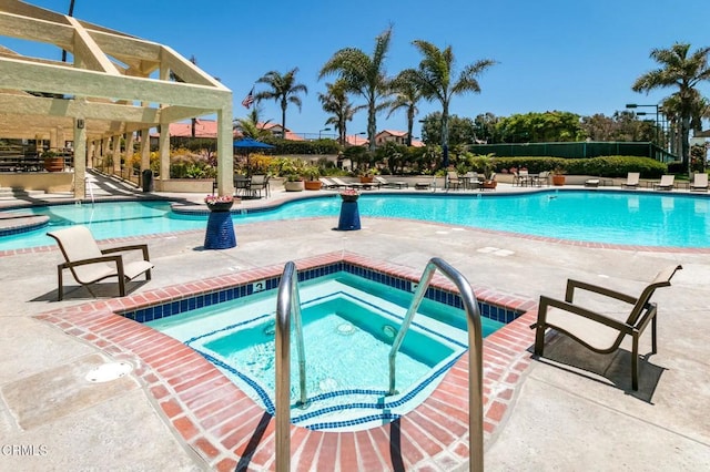 view of swimming pool with a pergola, a community hot tub, and a patio area