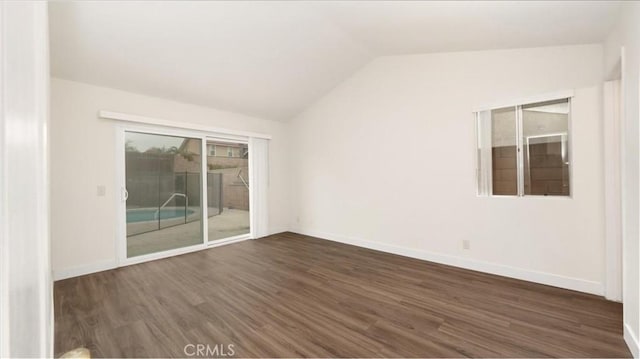 empty room with dark wood-type flooring and vaulted ceiling