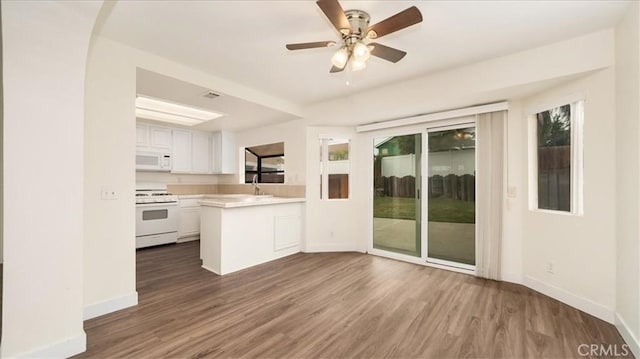 kitchen featuring dark hardwood / wood-style floors, white cabinetry, kitchen peninsula, plenty of natural light, and white appliances