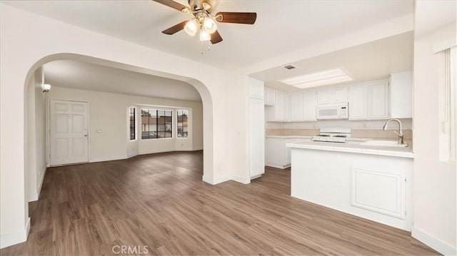 kitchen with white cabinetry, sink, dark wood-type flooring, and kitchen peninsula