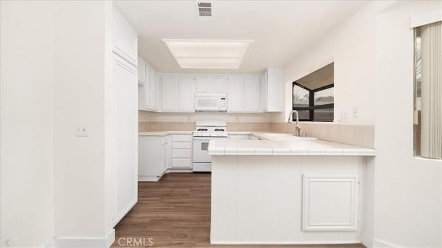 kitchen with dark wood-type flooring, sink, tile counters, white appliances, and white cabinets