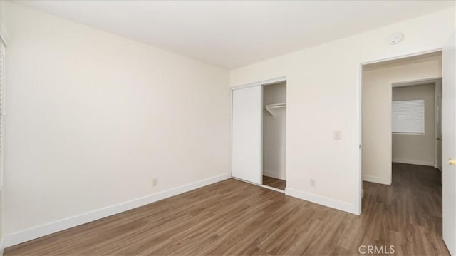 unfurnished bedroom featuring hardwood / wood-style floors and a closet