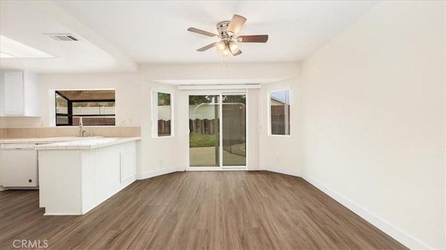 kitchen with dark wood-type flooring, white cabinets, white dishwasher, and kitchen peninsula