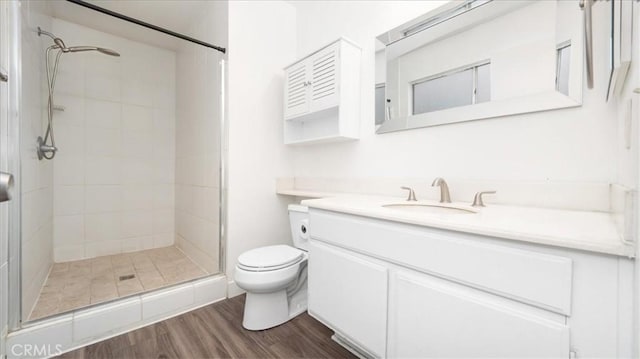 bathroom with hardwood / wood-style flooring, vanity, walk in shower, and toilet