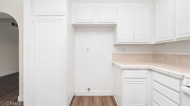 kitchen featuring hardwood / wood-style flooring, tile counters, and white cabinets