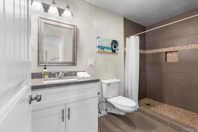 bathroom featuring walk in shower, vanity, toilet, and wood-type flooring