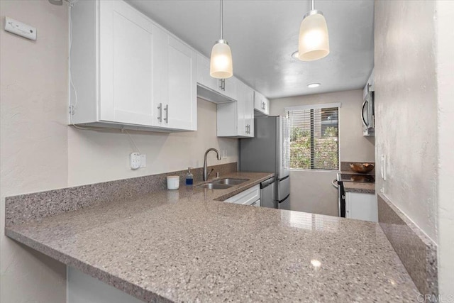 kitchen featuring sink, hanging light fixtures, stainless steel appliances, light stone counters, and white cabinets