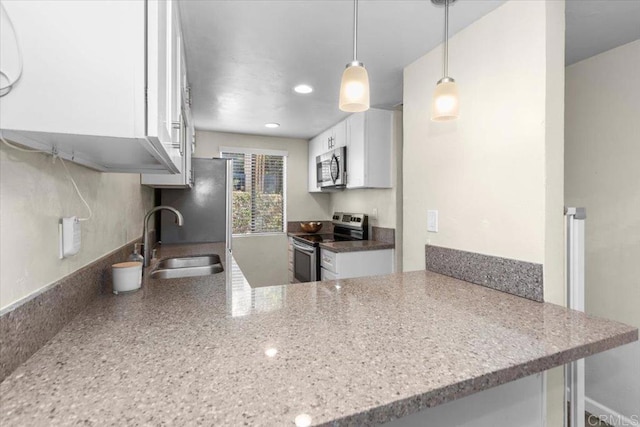 kitchen featuring sink, appliances with stainless steel finishes, kitchen peninsula, pendant lighting, and white cabinets