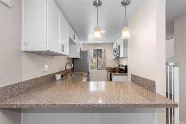 kitchen with appliances with stainless steel finishes, kitchen peninsula, and white cabinets