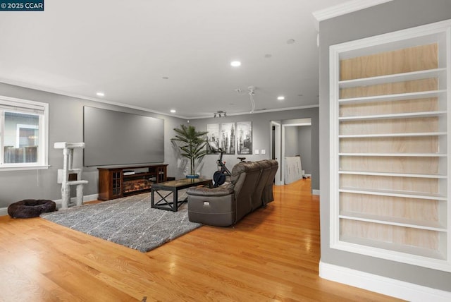 living room with crown molding, hardwood / wood-style flooring, and built in features