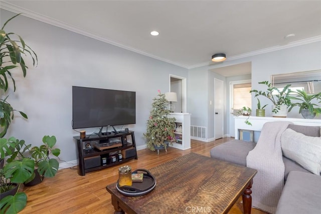 living room featuring crown molding and light hardwood / wood-style floors