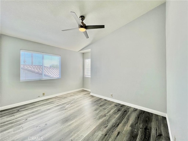 unfurnished room with wood-type flooring, vaulted ceiling, ceiling fan, and a textured ceiling