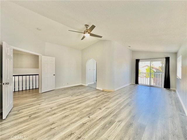 empty room with lofted ceiling, light hardwood / wood-style floors, and ceiling fan