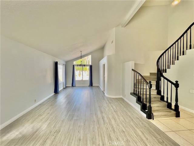 entryway featuring high vaulted ceiling, a chandelier, and light hardwood / wood-style floors