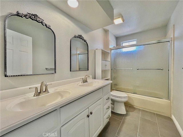 full bathroom featuring toilet, vanity, combined bath / shower with glass door, and tile patterned flooring