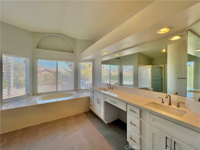 bathroom with tile patterned flooring, vanity, separate shower and tub, and lofted ceiling