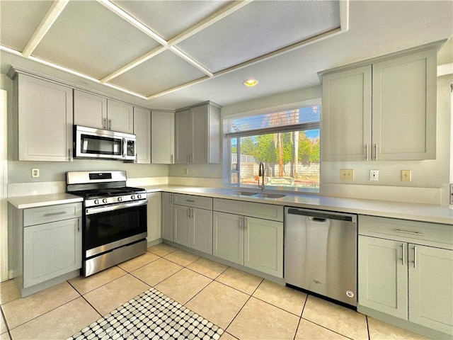 kitchen with light tile patterned flooring, appliances with stainless steel finishes, gray cabinets, and sink