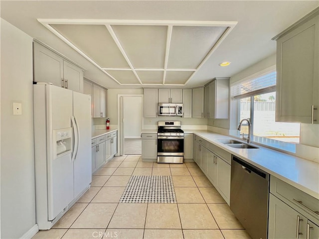 kitchen with stainless steel appliances, sink, light tile patterned floors, and gray cabinets