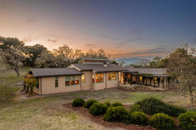 back house at dusk with a patio