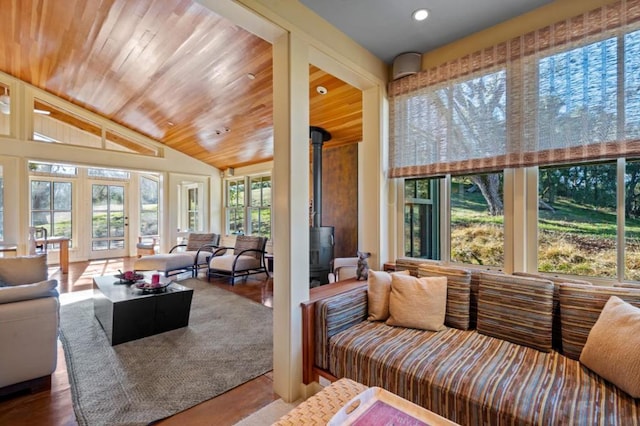 sunroom / solarium with vaulted ceiling, a wood stove, and wood ceiling