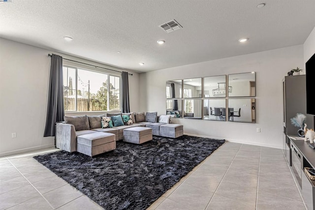 living room with light tile patterned flooring and a textured ceiling