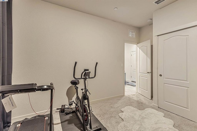 exercise room with light colored carpet