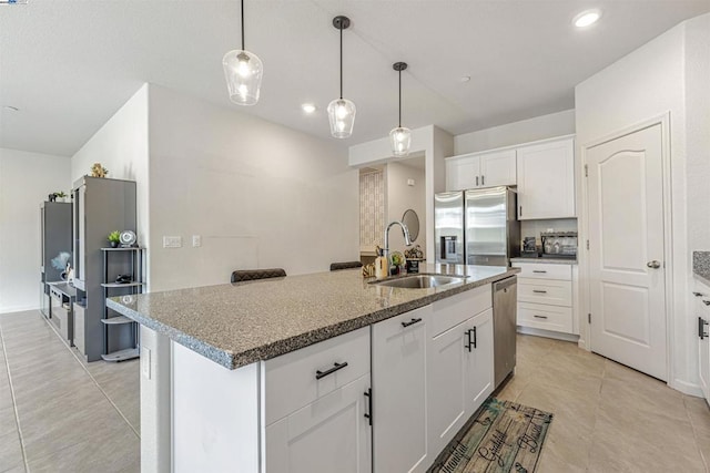 kitchen with appliances with stainless steel finishes, sink, a center island with sink, and white cabinets