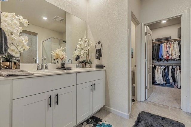 bathroom with tile patterned flooring, vanity, and a shower with shower door