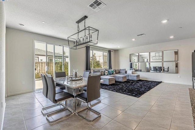 tiled dining space featuring a textured ceiling