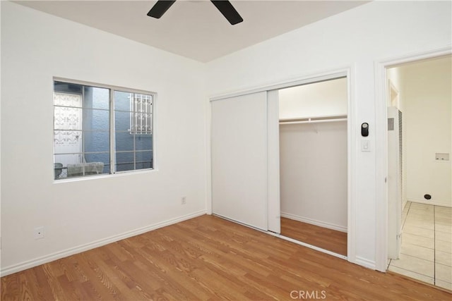 unfurnished bedroom with hardwood / wood-style flooring, a closet, and ceiling fan