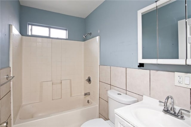 full bathroom featuring toilet, vanity, shower / washtub combination, and tile walls