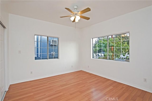 empty room with ceiling fan and light hardwood / wood-style flooring