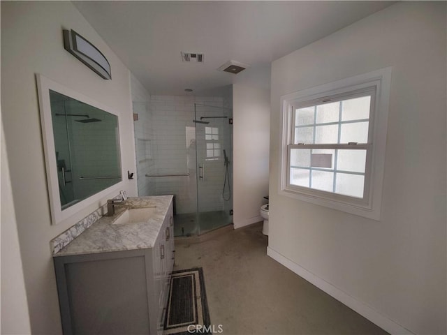 bathroom featuring vanity, toilet, and a shower with shower door