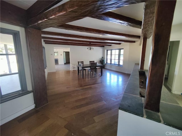 unfurnished dining area featuring an inviting chandelier, dark hardwood / wood-style flooring, and beam ceiling