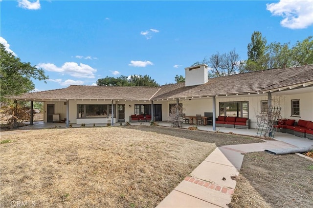 rear view of property featuring a patio and outdoor lounge area