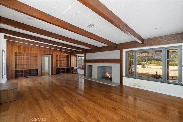 unfurnished living room with beam ceiling and wood-type flooring