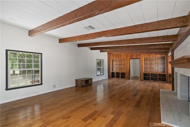 unfurnished living room featuring beamed ceiling and dark wood-type flooring