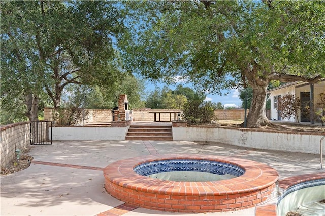 view of patio with an in ground hot tub