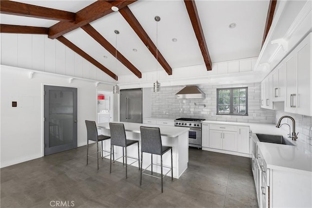 kitchen featuring pendant lighting, high quality appliances, white cabinetry, a center island, and wall chimney exhaust hood